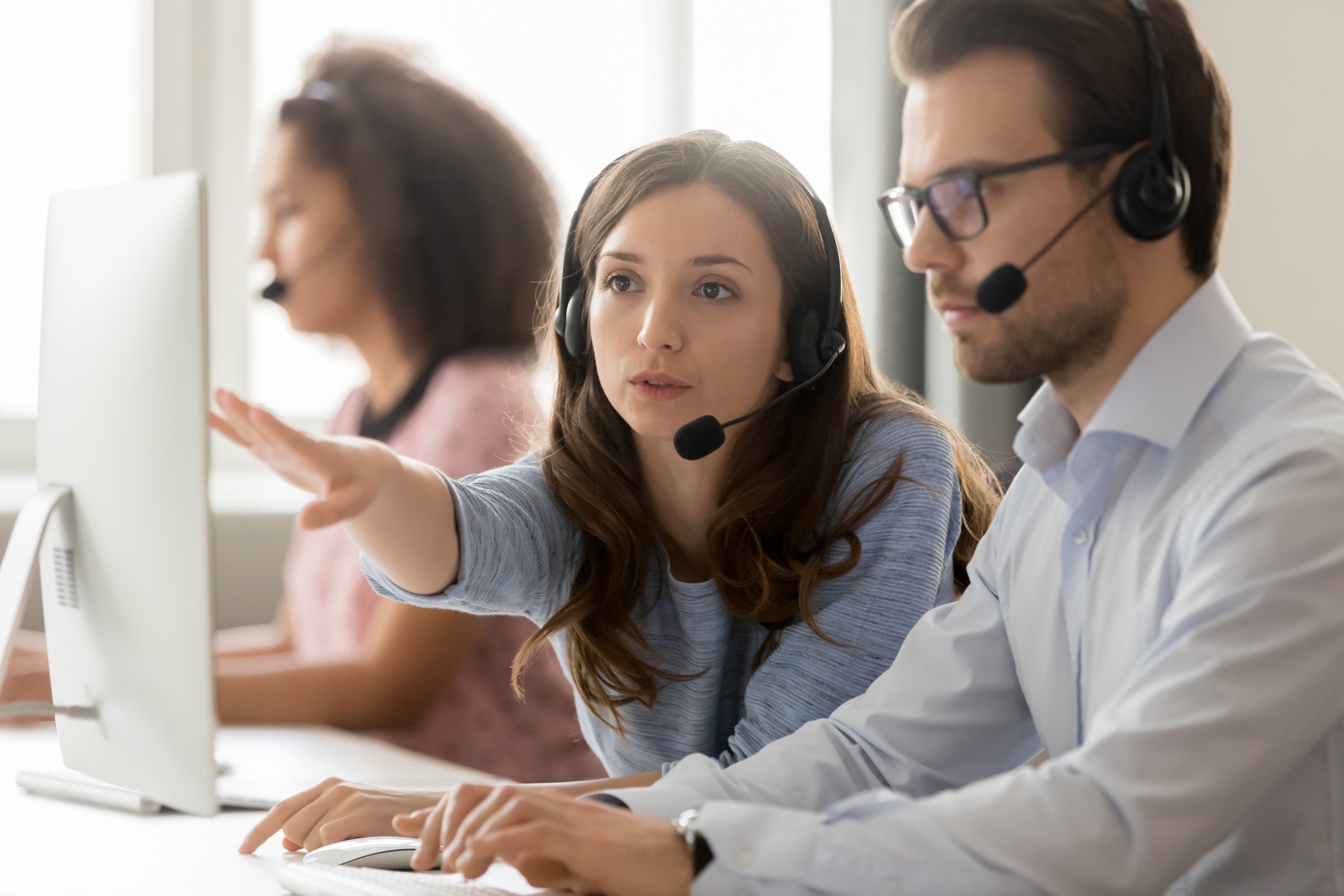 Call center female worker helping to man new employee colleague - About Us - Gemstone Logistics