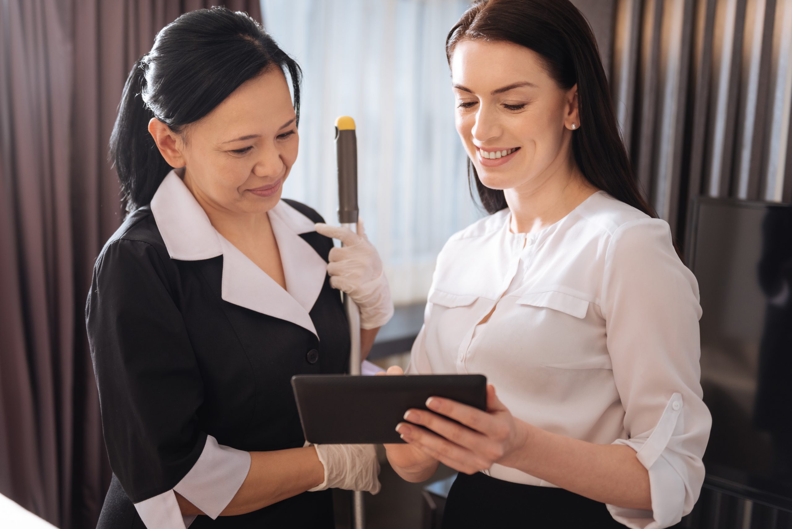 Joyful pleasant women looking at the tablet screen - Gemstone Logistics